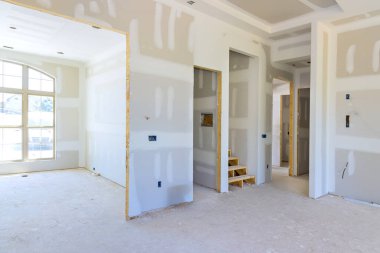 Plastering drywalling newly constructed house during construction phase clipart