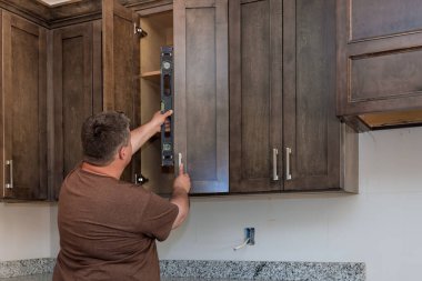 Yeni mutfak dolapları montajı sırasında, denetleyici seviye ölçüm aracı kullanarak kurulum kalitesini kontrol eder