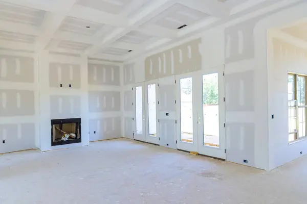 Stock image Plastering drywall in preparation for painting in newly constructed house