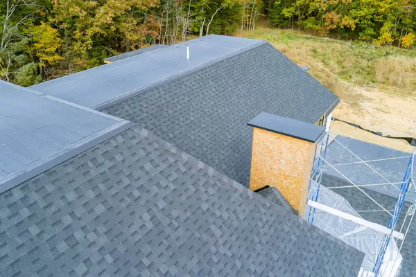 An asphalt shingle roof covers roof of newly built house