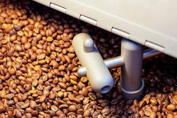 Process of roasting coffee beans involves mixing raw coffee beans roasting them in an oven machine