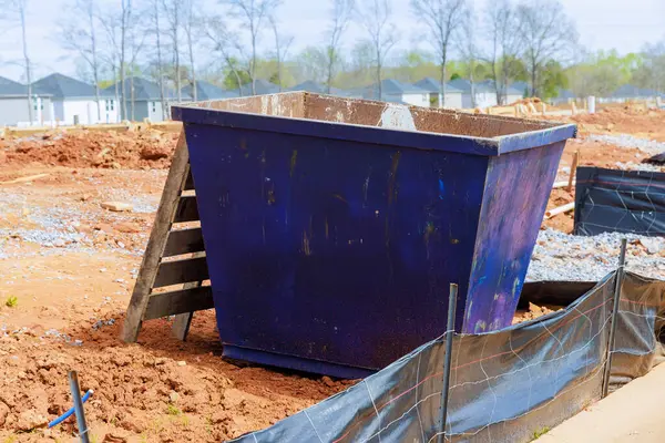 At construction site, metal container dumpster is used to store construction waste recyclable materials