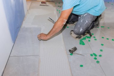 Tiler seramik zemini havan tutkalı üzerine serpiştiriyor.