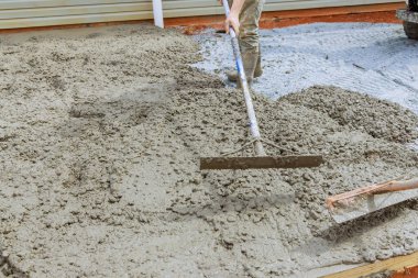 İnşaat şirketinin bir çalışanı betonu düzleştirmek için özel araç kullanır