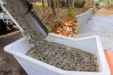 İnşaat alanı beton arabalı, el arabası çimento kamyonunda ıslak çimento var.