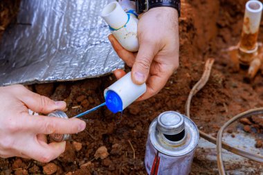 Plastik boruyu yapıştırıcı ile yapıştırmadan önce tesisatçı boruyu yapıştırıcıyla kapatıyor.