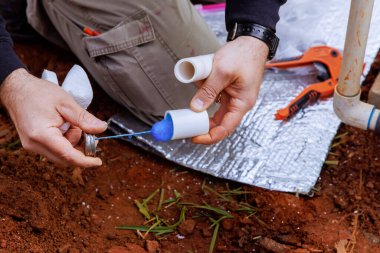 Tesisatçı yapıştırılmadan önce bir pvc borusunu yapıştırıcı ile kapatır.