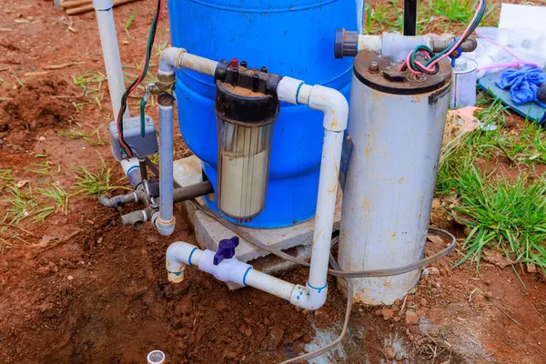 Pemasang Pipa Menghubungkan Air Pompa Sumur Dengan Pipa Bawah Tanah Stok Gambar
