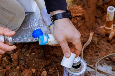 Tecrübeli bir tesisatçı yapıştırmadan önce PVC borusuna yapıştırıcı sürer.