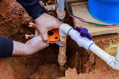 Tesisatçı tarafından özel bir makasla plastik PVC boru kesmek