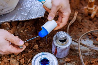 Tesisatçı substrata yapıştırmadan önce plastik boruyu yapıştırır.