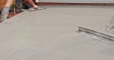 İnşaat işçisi özel araçlar kullanarak betonu düzleştiriyor