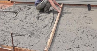 Beton işi inşaat işçisi, çimento temeli harcı seviyesinde özel aletler kullanır.