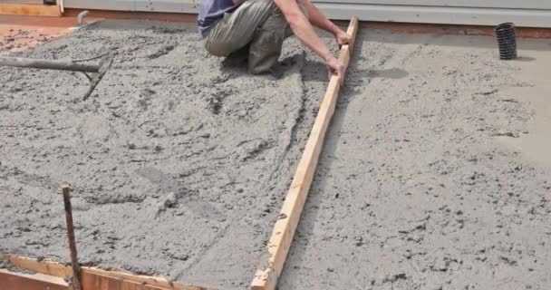 具体的な仕事の建設労働者はセメント基礎のモルタルを水平にするのに特別な用具を使用します — ストック動画