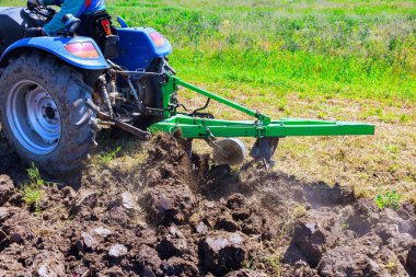 İlkbaharda, traktör tarlayı sürüyor, toprağı işliyor, tahıl ekmeye hazırlıyor.