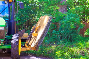Çim biçme makineli belediye servis traktörü yolun her iki tarafında da çim dalları kesiyor