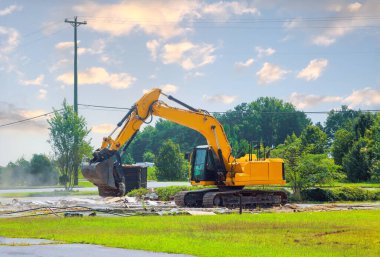 Bir kazıcı inşaat atıklarını çöp konteynırına yüklüyor