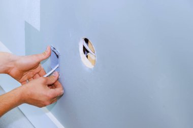 Bir elektrikçi dairenin yenilenmesi sırasında yeni bir soket kutusu yerleştirdi