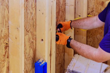 Yerleşim yerinin iç kısımlarına elektrik kabloları yerleştirilirken, bir elektrikçi kabloları yerleştirir