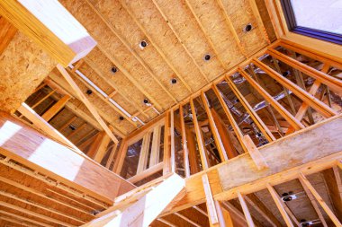 Tahta kirişli yeni ev inşaatı için tamamlanmamış bir ahşap çerçeve inşa ediliyor.