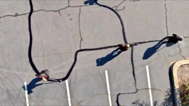 Çalışan yama sırasında asfalt çatlaklarını doldurarak zift emülsiyonu yol yüzey yenileme çalışmalarını gerçekleştirir