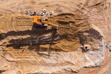 Bir kazıcı tarafından kanalizasyon borularına siper hazırlamak için toprak çalışmaları yapılıyor.