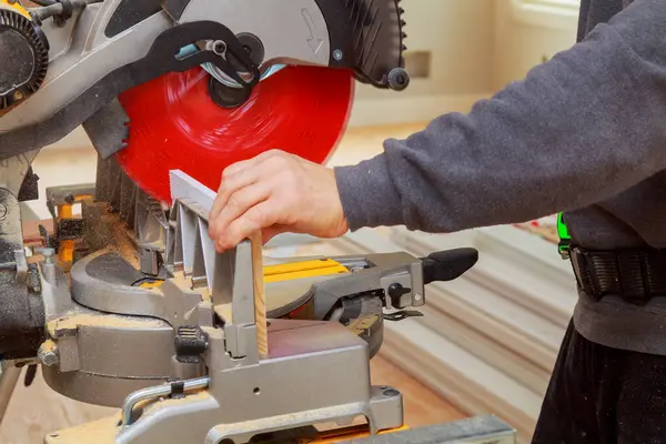 Stock image Contractor of using circular saw is cutting wooden moldings on circular saw before installing