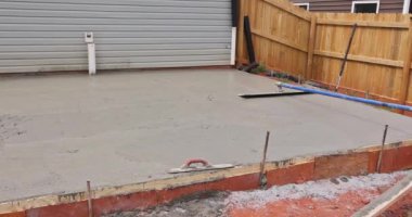 İşçiler, özel çelik malayla ıslak beton temelli havan topu seviyesinde..