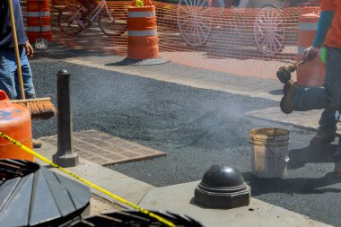 İşçiler tarafından yeniden inşa edilen yolun hasarlı kısmına tamirat yapılıyor.