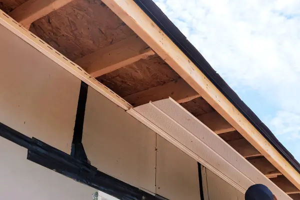 stock image Installation polyvinyl soffit at roof corners of house with rafters