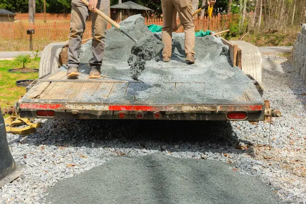 stock image When leveling driveway, workers filling parking lot near house with small stone