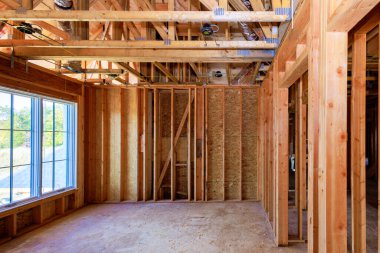 Şu anda, yeni konut projesi bitmemiş bir ahşap çerçeveyi ahşap kirişler, direkler ve iskeletle çerçeveliyor.