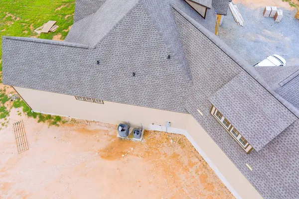 stock image Construction roof of new house is covered with rubber asphalt roof shingles