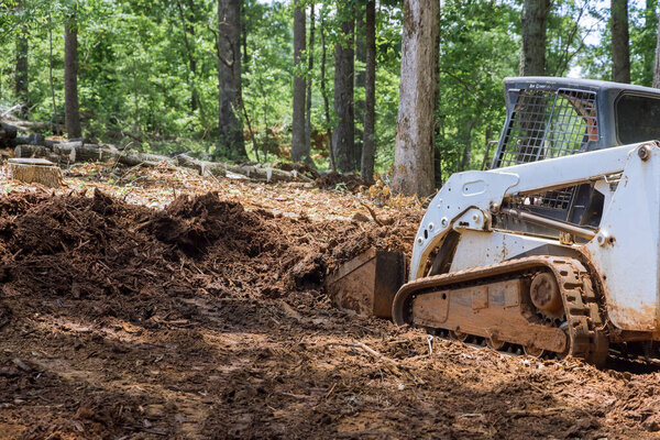 Землеройная тракторная площадка во время строительства двора