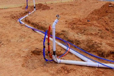 Yeraltı su borularını hijyenik su borularına yerleştirerek yeni ev temellerine beton dökmeye hazırlanıyorlar.