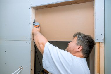 İşçi alçıpanı çoklu araç kullanarak keser