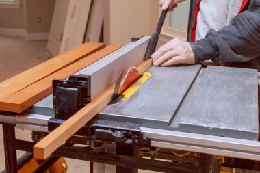 Elektrikli testereyle ahşap dolap dolgusu kesmek.