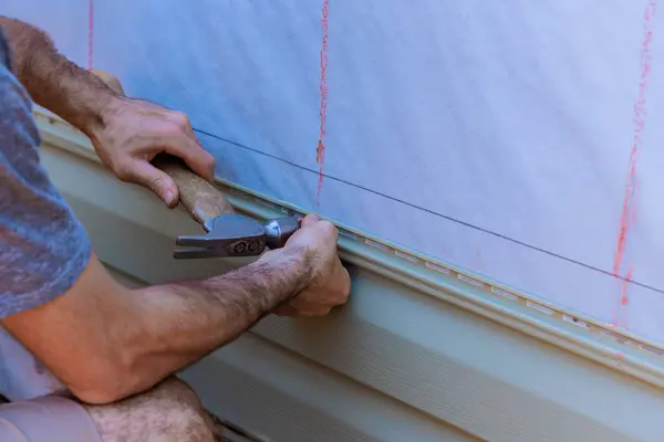 stock image During construction facade of new home, handyman installed vinyl PVC siding