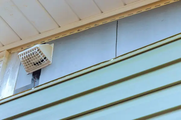 stock image Installing vinyl siding plastic panels on facade wall of new home by an employee