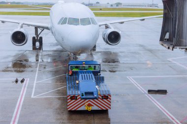Uçak, yağmur sırasında kalkışa hazırlanmak için terminal kapısından aşağı yuvarlanır.