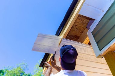 Şirket temsilcisi ön cephe tavanına plastik paneller yerleştirdi. Yeni ev.