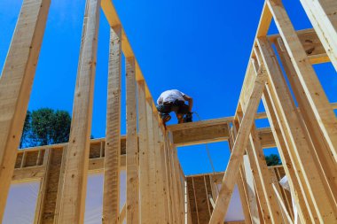 Hava çivisi çekici kullanarak, müteahhit çivileri çakıyor.