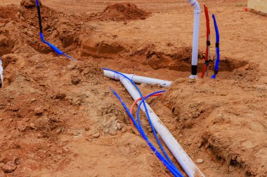 Yeni ev temeline beton dökmeden önce yeraltı su boruları döşeniyor.