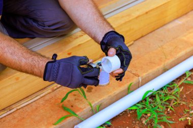 Tesisat şirketinin bir çalışanı su tedarik hattının kurulumu sırasında plastik PVC su sistemlerini yapıştırdı