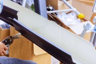 İşçi alüminyum yağmur oluklarını makine aracı kullanılarak büküldükten sonra gerekli boyuta getirir