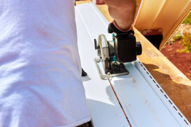 İşçiler yerleştirmeden önce plastik kaplamayı gerekli boyuta kestiler