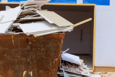 Alçıpan parçaları atılırken, inşaat atığı için konteynıra kondular..