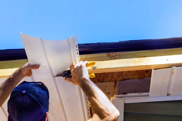 stock image Incorporating vinyl soffit plastic panels into facade ceiling of new house by an employee