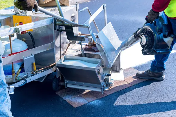 stock image Workers apply markings signs to road after asphalt has been laid