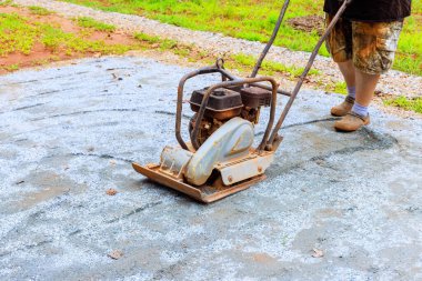 Havuz platformu inşaatı sırasında titreşimli tamping makinesi tarafından kumun sıkıştırılması